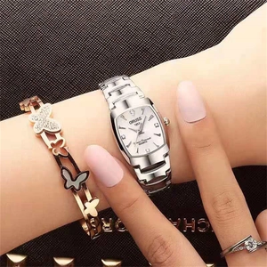 Close-up of women silver tonneau quartz watch with elegant butterfly bracelet and ring