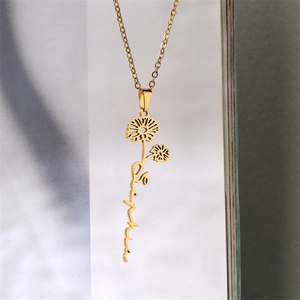 Detail of gold daisy pendant with cursive month text on a delicate link chain