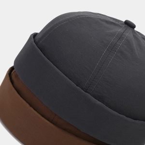 Close-up of durable fabric texture and neat stitching on gray and brown miki hats