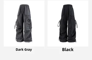 Dettaglio dei pantaloni cargo a vita alta in grigio scuro e nero con fondo a coulisse