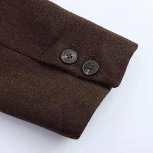 Detailed macro view of dark brown wool coat cuffs featuring two matching dark buttons