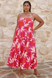 Detail of floral print summer maxi dress featuring a layered tiered skirt and thin straps