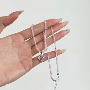 Detailed close-up of S925 sterling silver four-leaf clover pendant with pink crystal beads