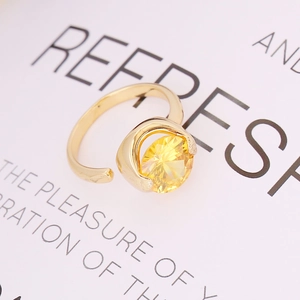 Macro detail of gold open ring featuring a large yellow round-cut faceted zircon gemstone