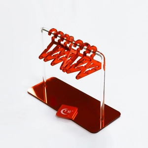 Macro detail of acrylic earring stand with orange hangers on clear stable base