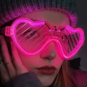 Pink heart-shaped LED shutter glasses worn by a female model in a dark party setting