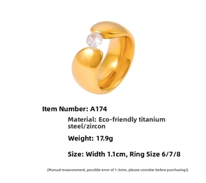 Nahaufnahme eines breiten 18k vergoldeten Titanrings mit einem einzelnen Zirkonia Stein