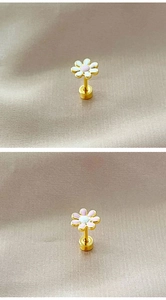 Macro view of floral enamel stud earrings in pink and white on a champagne silk background