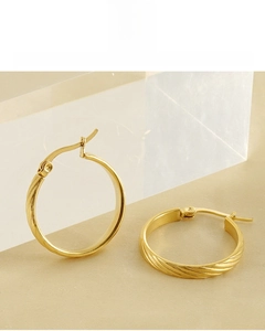Detail of 18K gold vacuum plated earrings featuring textured twist pattern and buckle clasp
