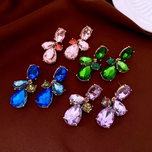 Vue détaillée de quatre paires de boucles d'oreilles en cristal sur tissu de luxe