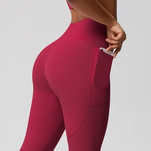Detail of red high-waisted yoga leggings with functional side pocket for smartphone