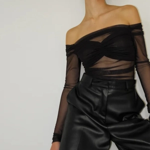 Detail view of black off-shoulder mesh long sleeve top with ruched texture design