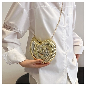 Detail of golden nautilus clutch with spiral texture and elegant chain strap for women