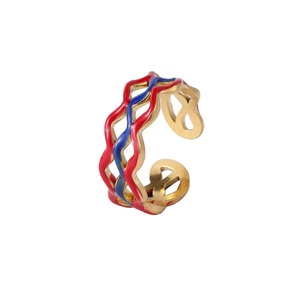 Détail d'une bague ondulée avec de l'émail rouge et bleu sur une finition dorée