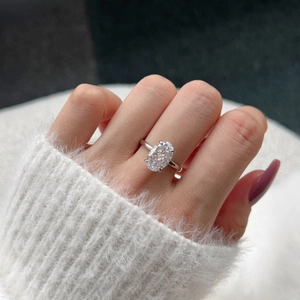 Close-up of S925 silver ring with oval cut zircon on a model wearing white sweater