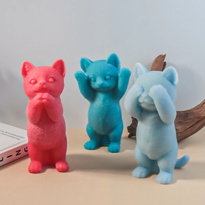 Trois figurines de chats floqués en rouge et bleu adoptant des poses anthropomorphes