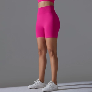 Detail view of seamless rose red high-waisted yoga shorts with tummy control and lifting effect
