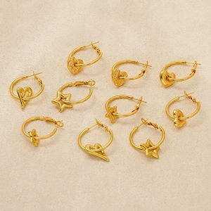 Gold titanium steel hoop earrings with heart and star pendants on cream background