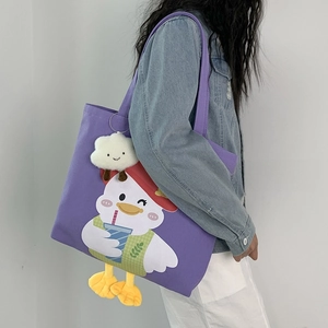 Detail of purple canvas tote bag with cartoon duck print and white cloud pendant