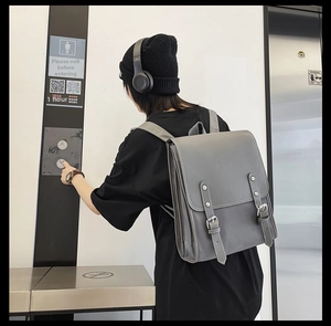 Detail of grey vintage soft leather backpack with double buckle flap for daily commute