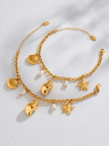 Détail d'un bracelet doré thème océan avec perles naturelles, coquillages et étoiles de mer