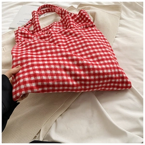 Detail view of the soft red and white checkered tote bag fabric on light textile background