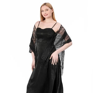 Detail of elegant black lace shawl with fringe trim and sheer floral lace texture