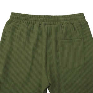 Detail of army green ribbed pants featuring elastic waist and back pocket texture
