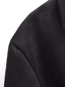 Detailed close-up of the black suede texture and shoulder stitching on the slim-fit top