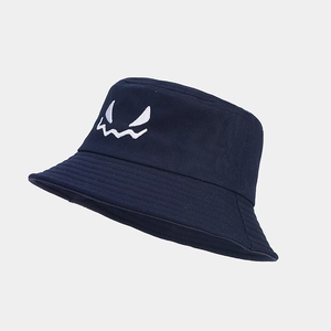 Detail of white ghost face embroidery on a navy blue cotton canvas bucket hat