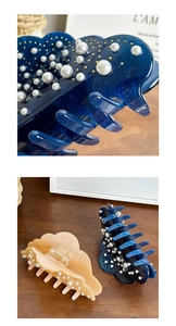 Detail of elegant resin hair claws with pearls and glitter on a rustic wooden background
