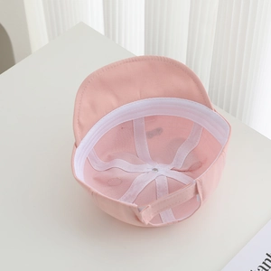 Detailed interior of pink baby baseball cap showing soft cotton lining and adjustable strap