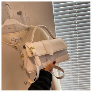 Détail du sac à main en cuir blanc avec coutures verticales et boucle en métal chic