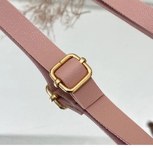 Detailed macro view of pink litchi grain leather strap with adjustable gold buckle hardware