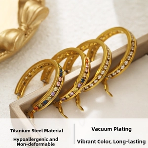 Detail view of gold titanium earrings featuring a rainbow zircon inlay and secure clasp