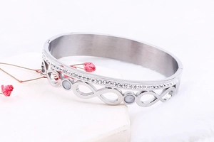 Close-up of infinity symbol silver bangle with double-row crystals on stone tray