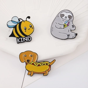 Cute cartoon enamel pins set featuring a bee, sloth, and hot dog dachshund on a white tray