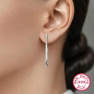 Close-up of minimalist S925 sterling silver geometric bar earrings worn on the ear