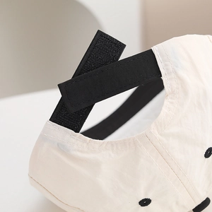 Détail de la sangle réglable à scratch noir sur la casquette de baseball beige bébé