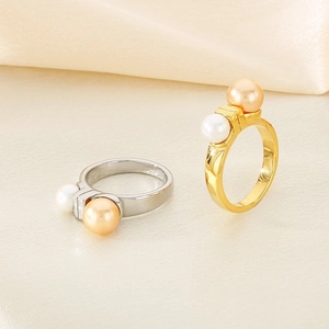 French style stainless steel rings with white and champagne pearls on silk background