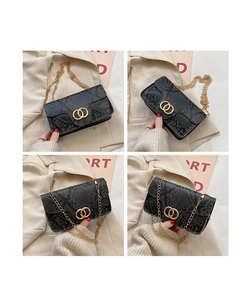 Detail of snake skin texture and golden circular magnetic buckle on black crossbody bag