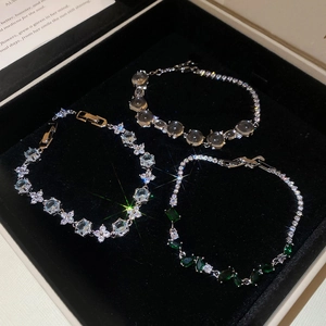 Détail de bracelets élégants en zircon avec pierres bleues, grises et vertes en boîte à bijoux