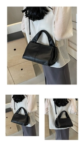 Detailed view of black leather shoulder bag showing delicate grain texture on the back