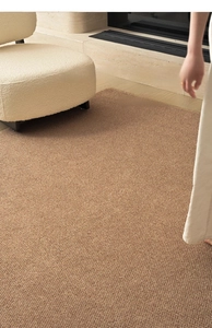 Close-up of cross-weave sisal texture carpet next to a white fleece chair