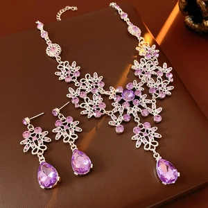 Close-up of vintage floral necklace and earrings set with purple rhinestones
