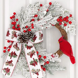 Christmas wreath with cardinal bird, red berries, and frosted pine on a white door background