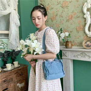 Close-up of light blue denim tote bag with matching fabric handles and minimalist stitching