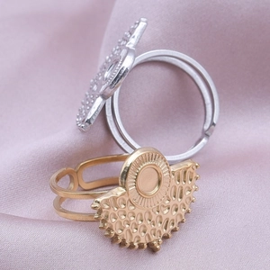 Detail of adjustable sunburst rings in gold and silver on purple silk fabric