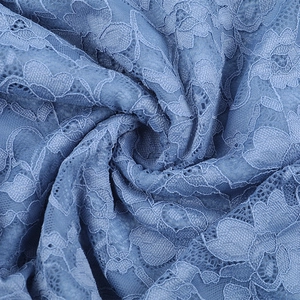 Detail of blue lace fabric with intricate floral patterns and soft sheer texture