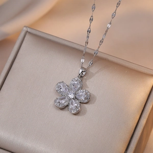 Silver flower pendant necklace with five pear-shaped zircon petals on a beige display pad